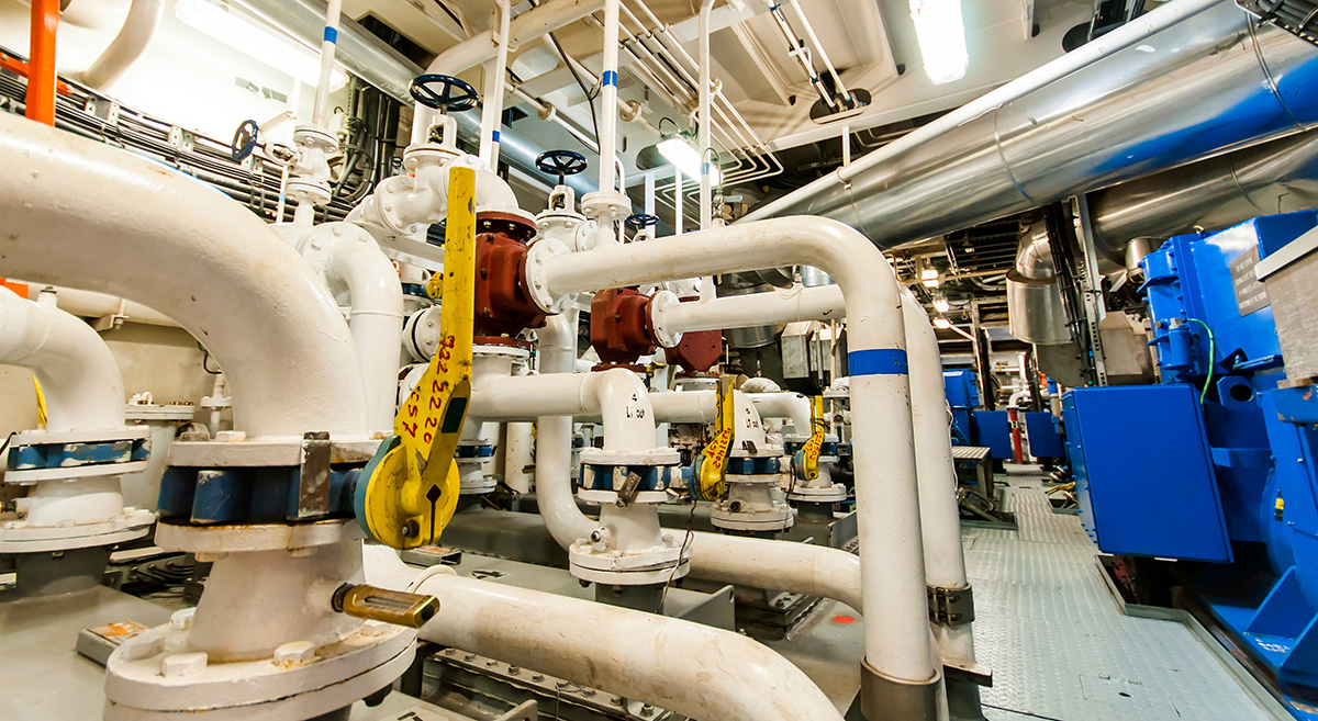 Marine engine room showing complex pipe and valve systems