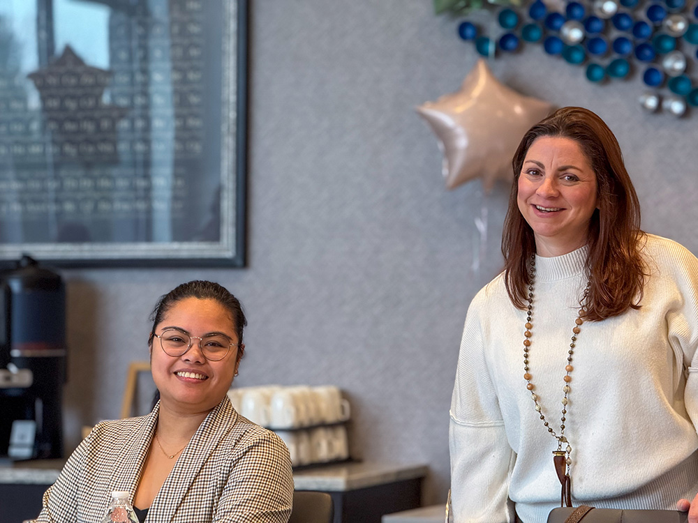 Two Women Who Metric members smiling at an event decorated with star balloons