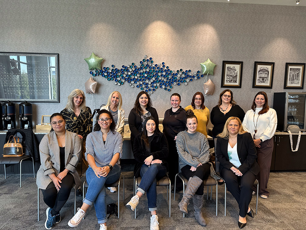 Women Who Metric attendees group photo seated and standing in a conference room